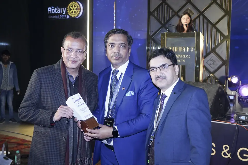 Three guests holding an award trophy at the Rotary Club Delhi Shahdara MSME awards
