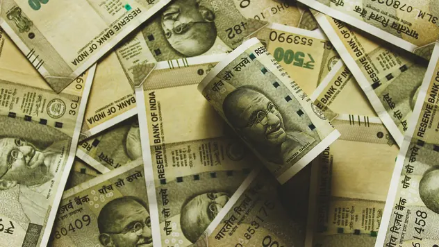 Indian rupee currency notes of different denominations spread across a table