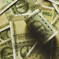 Indian rupee currency notes of different denominations spread across a table